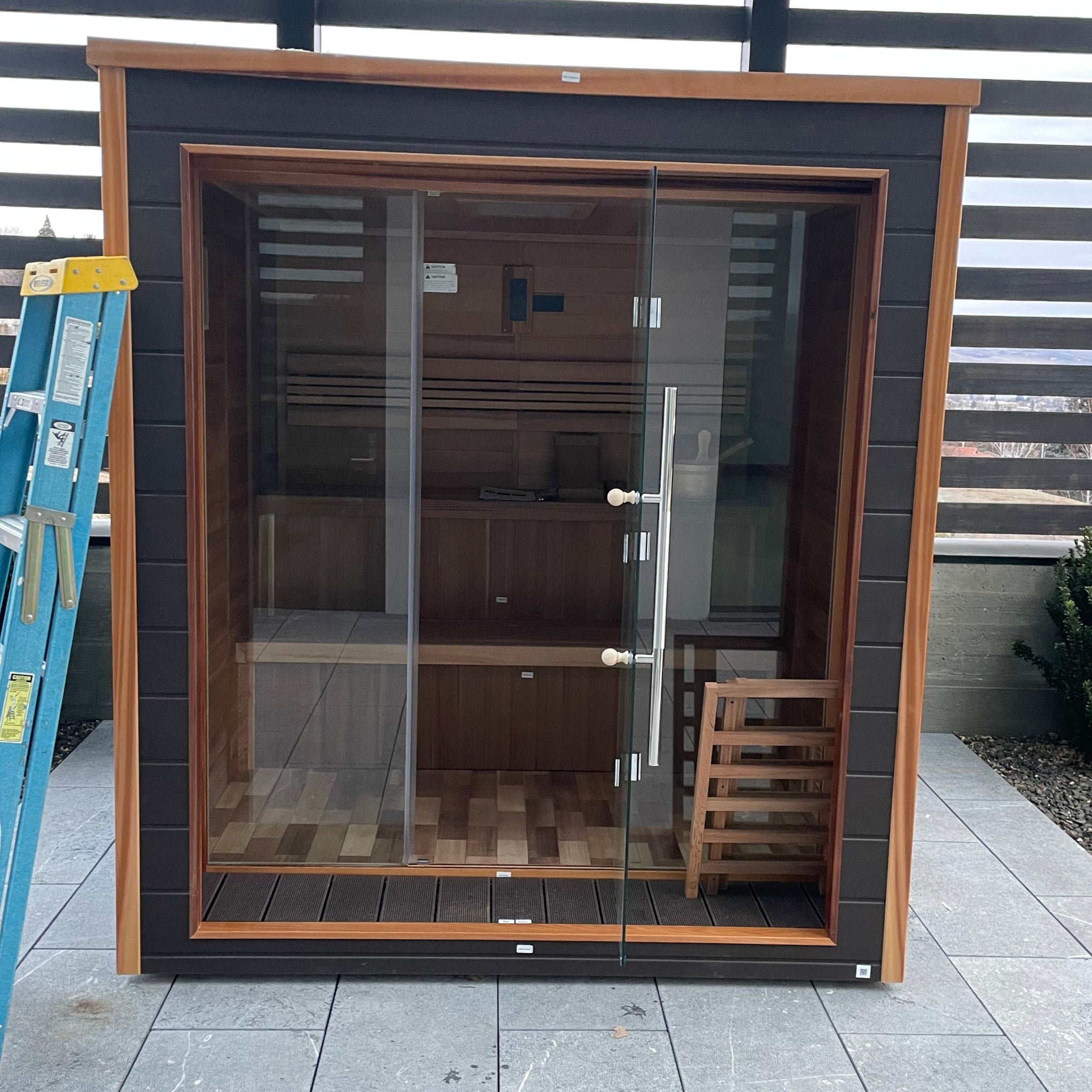 Traditional sauna heater and volcanic stones inside a Golden Designs 6-person outdoor cedar sauna.