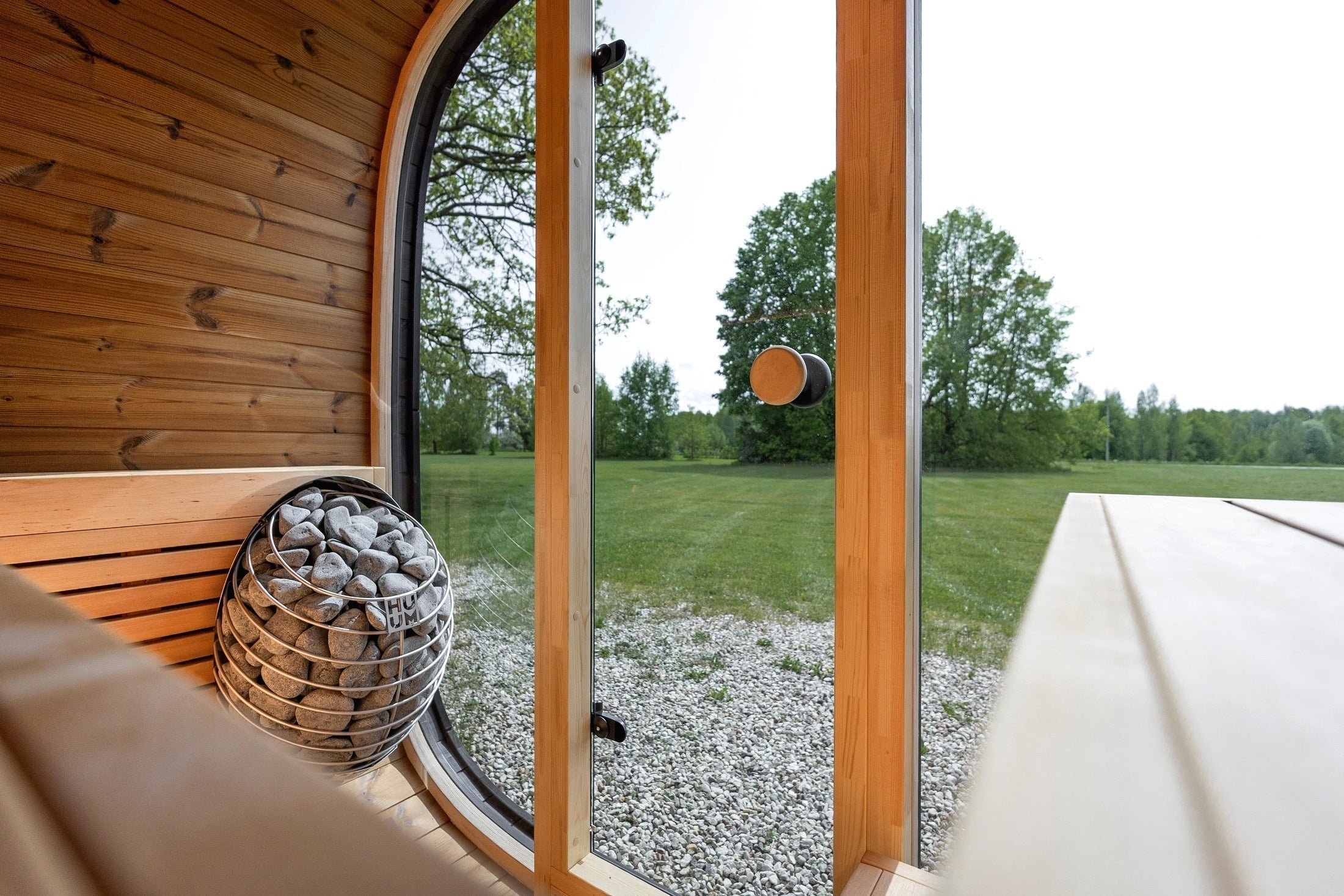 Modern black outdoor sauna cabin by Leil, featuring premium Thermowood construction, smoked glass walls, and comfortable alder wood seating