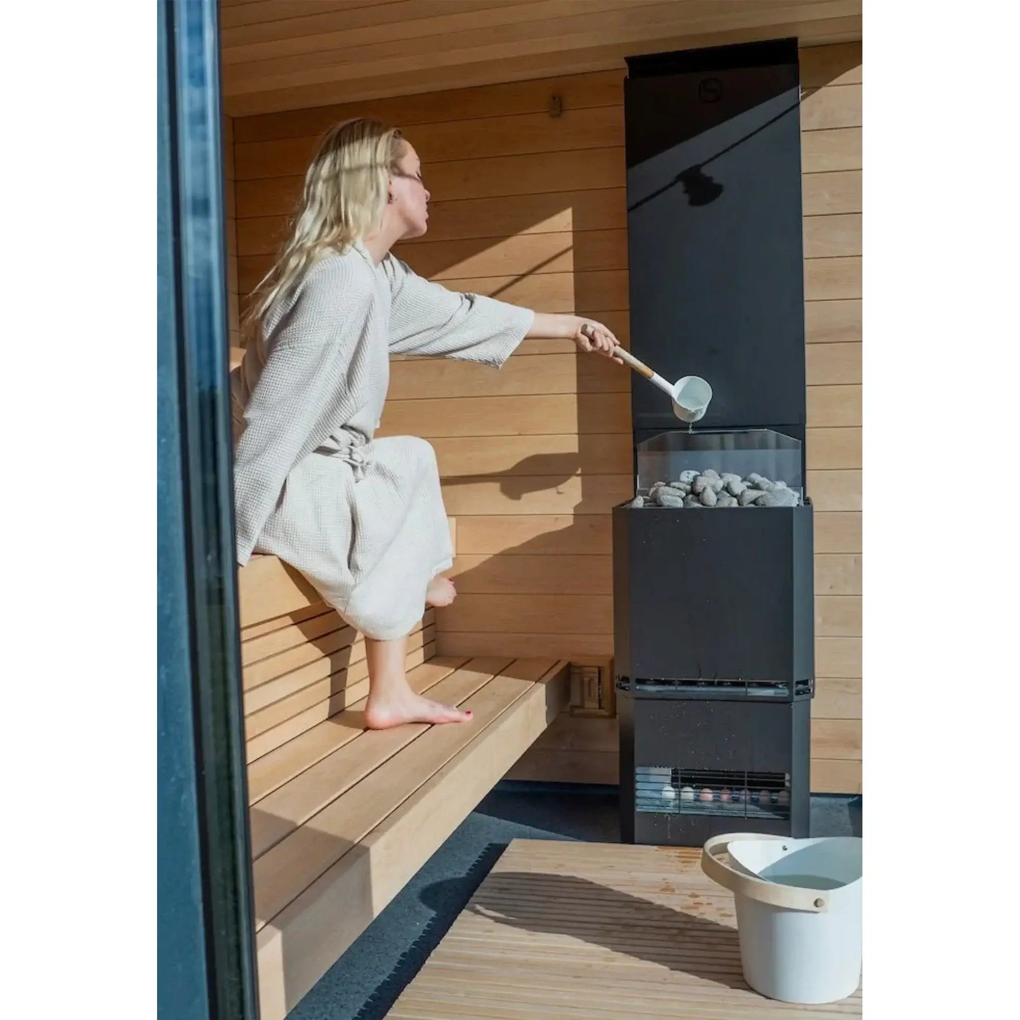 SaunaLife G6 pre-built outdoor sauna cabin featuring alder wood interior benches and sleek black exterior cladding