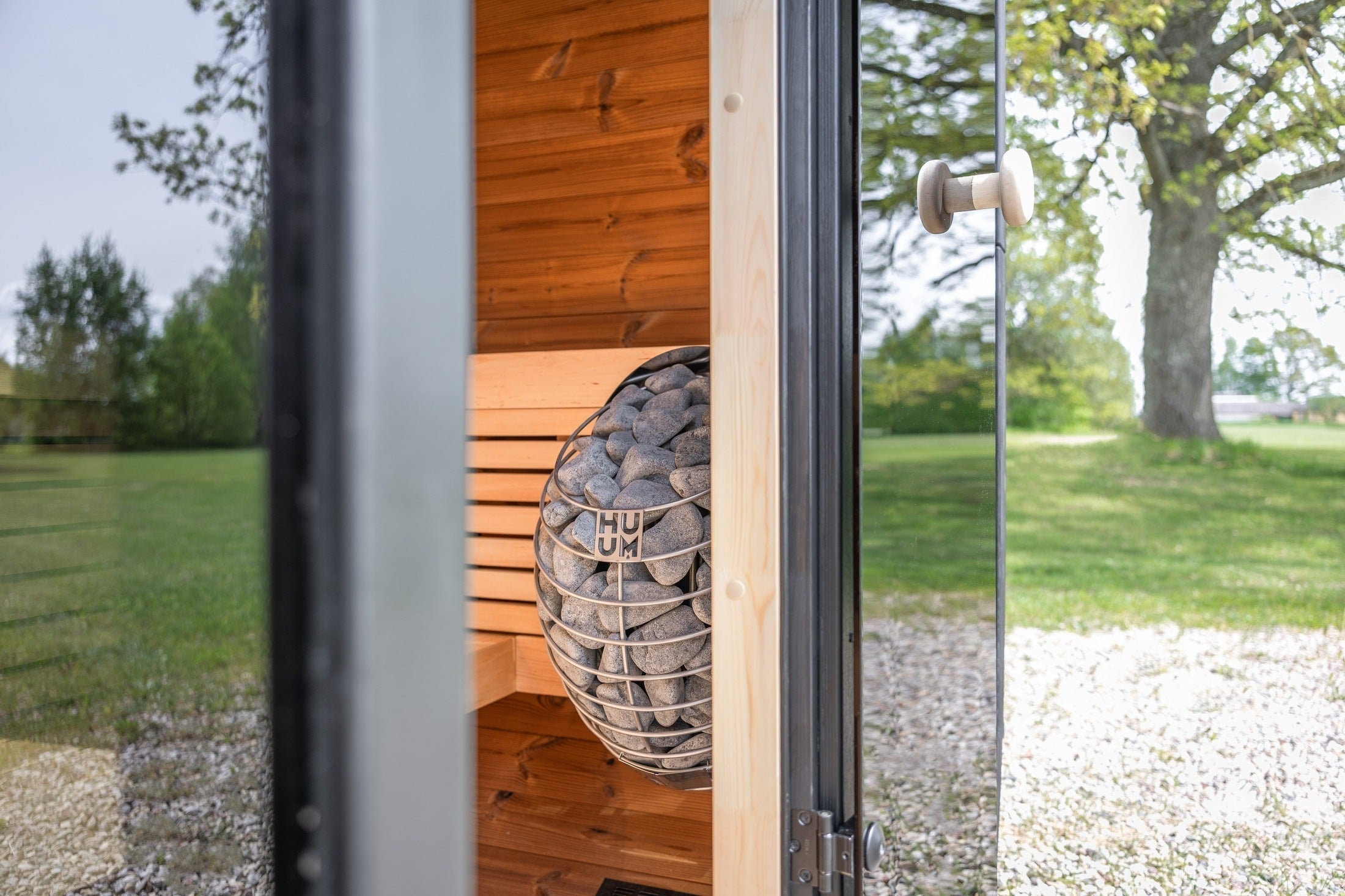 Contemporary Leil Black Cube outdoor sauna kit featuring minimalist architecture, black wood exterior, tempered glass front, and premium wellness design