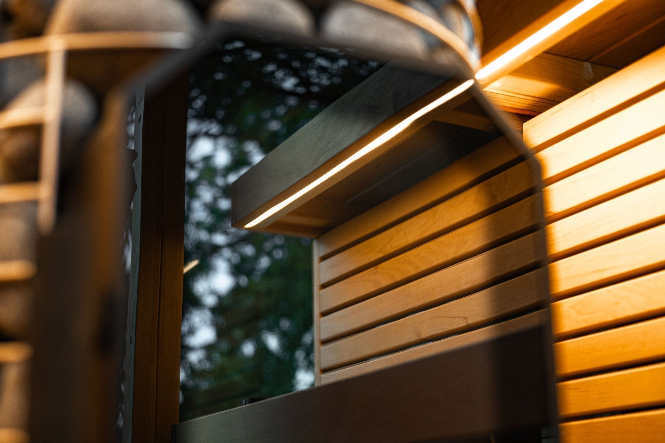 Premium outdoor sauna for six people by Leil featuring durable ThermoWood, opposing benches, and modern black cube architecture