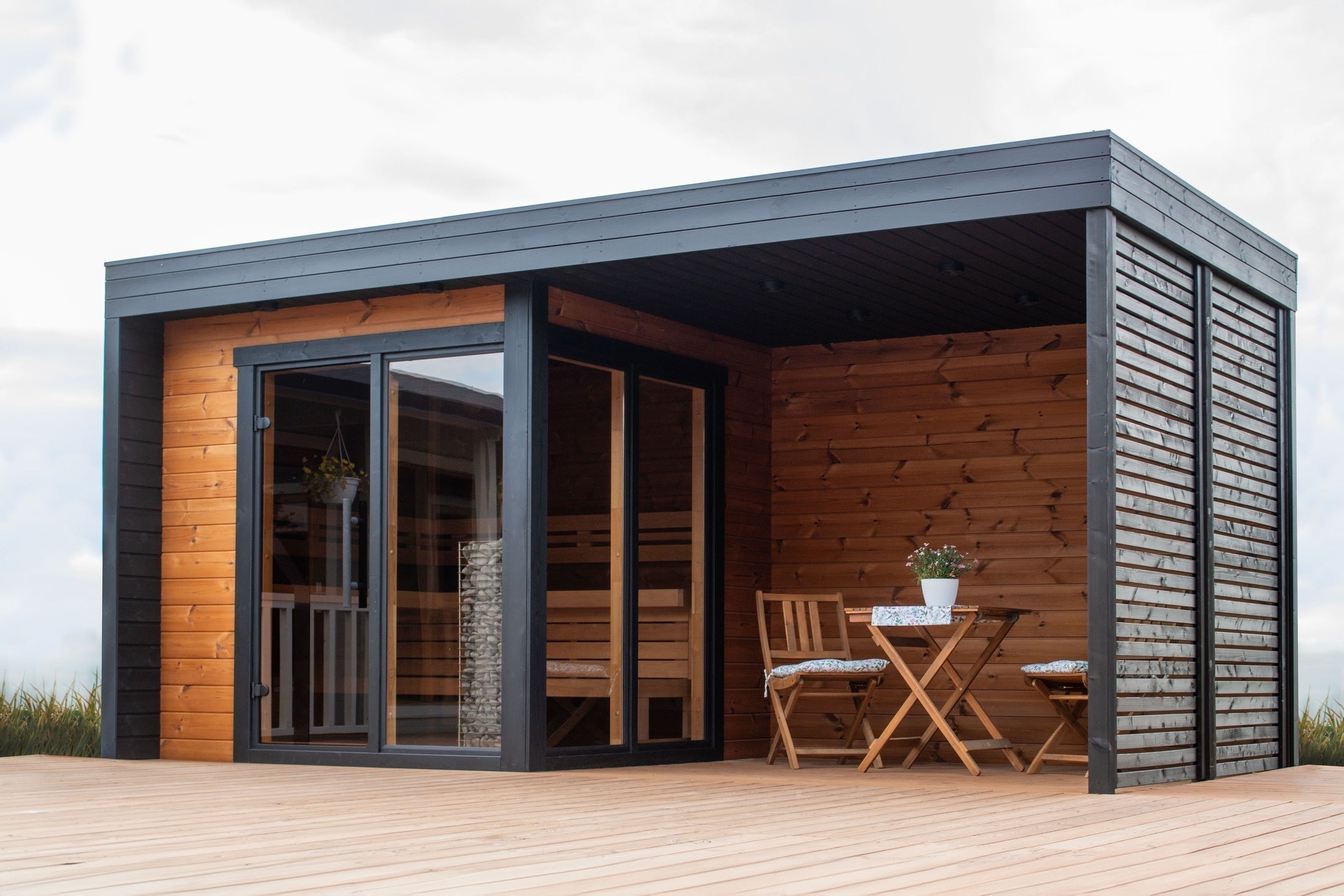Leil S Plus 4 Person Outdoor Sauna Kit made of ThermoWood, modern backyard sauna with outdoor wellness deck
