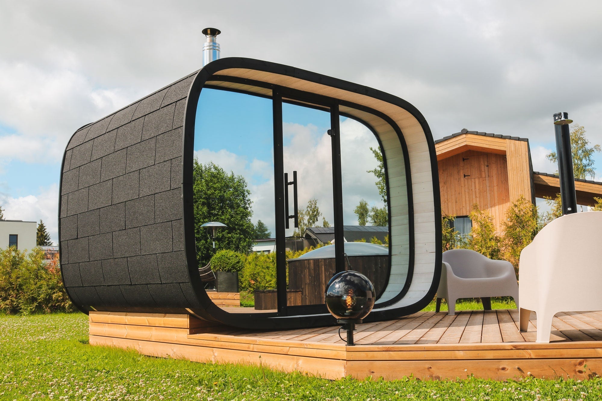 Modern round cube outdoor sauna cabin made from ThermoWood with Nordic Estonian design